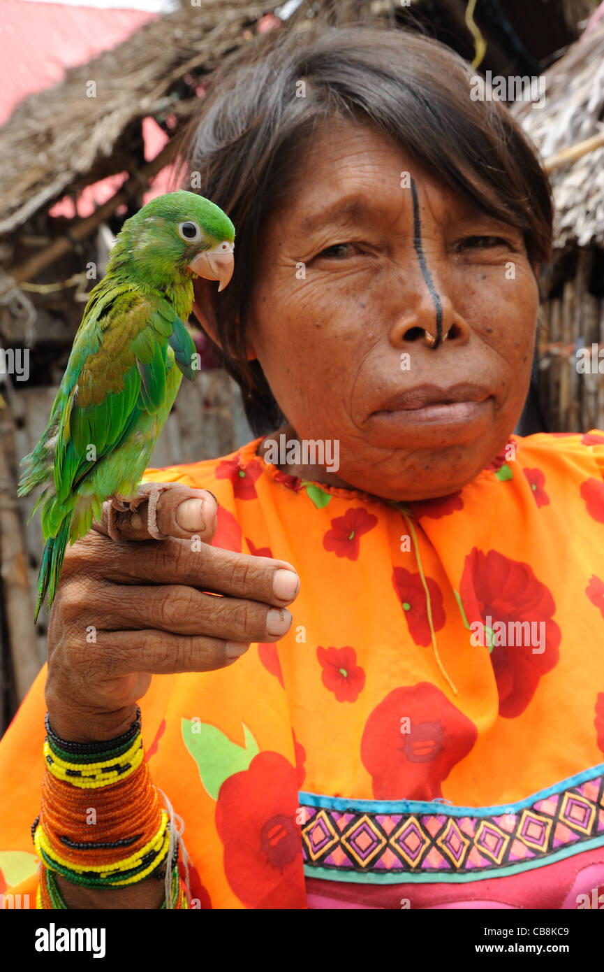 Guna indian woman with green parrot at Corbisky island in Guna Yala, Panama. Stock Photo