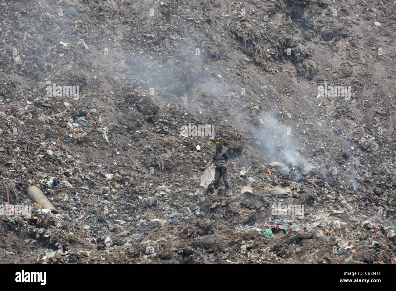 Poor Roma man (Gipsy) collecting garbage from huge refuse dump near town of Pazardzhik, Bulgaria Stock Photo
