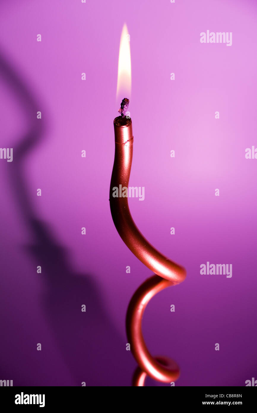 burning candle on colourful vivid background Stock Photo