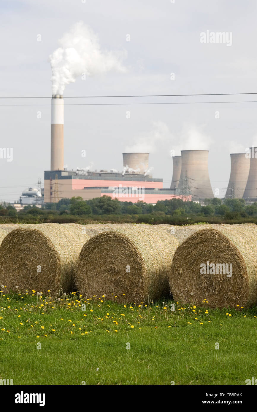 Cottam Power Station Cooling Towers viewed over Round Hay Bales in Summer Field Stock Photo