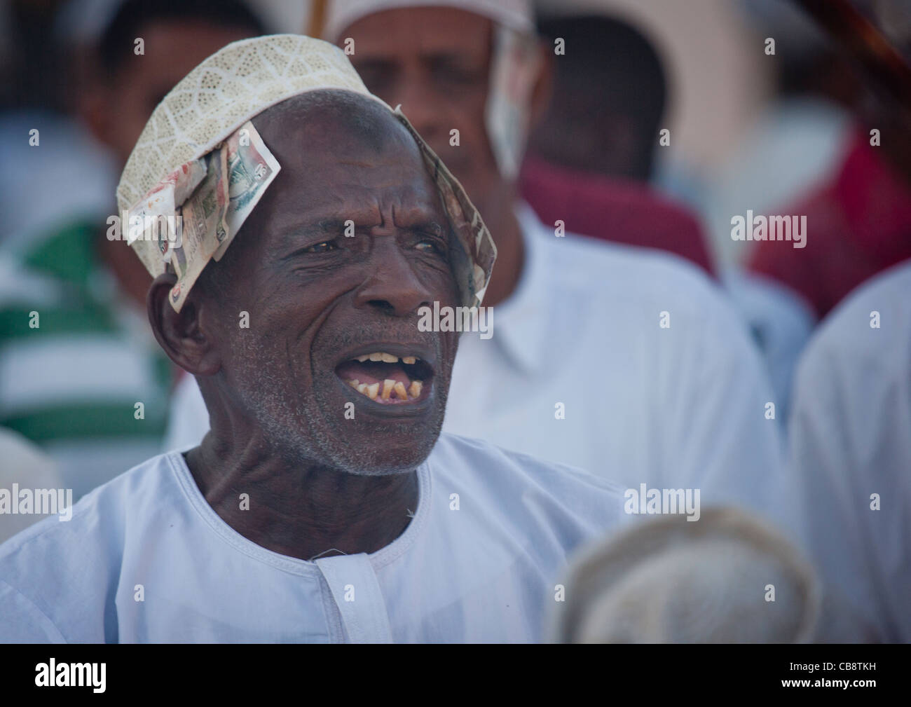 Senior Man Singing And Directing Goma Stick Dance At Maulidi Festival, Lamu, Kenya Stock Photo