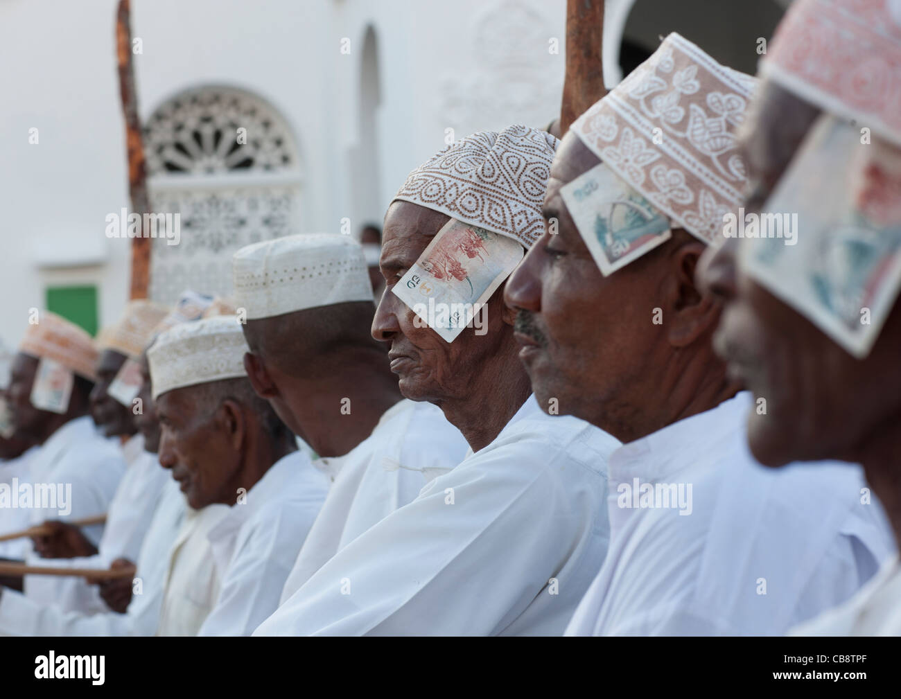 Men In A Row With Banknotes In Kofia Hat, Maulidi Festival, Lamu Kenya Stock Photo