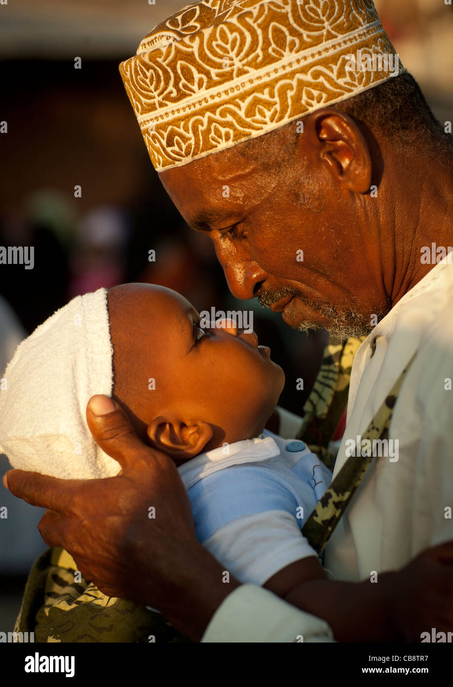 Father Carrying Small Baby  With Coaled Eyelids During Maulidi, Lamu, Kenya Stock Photo