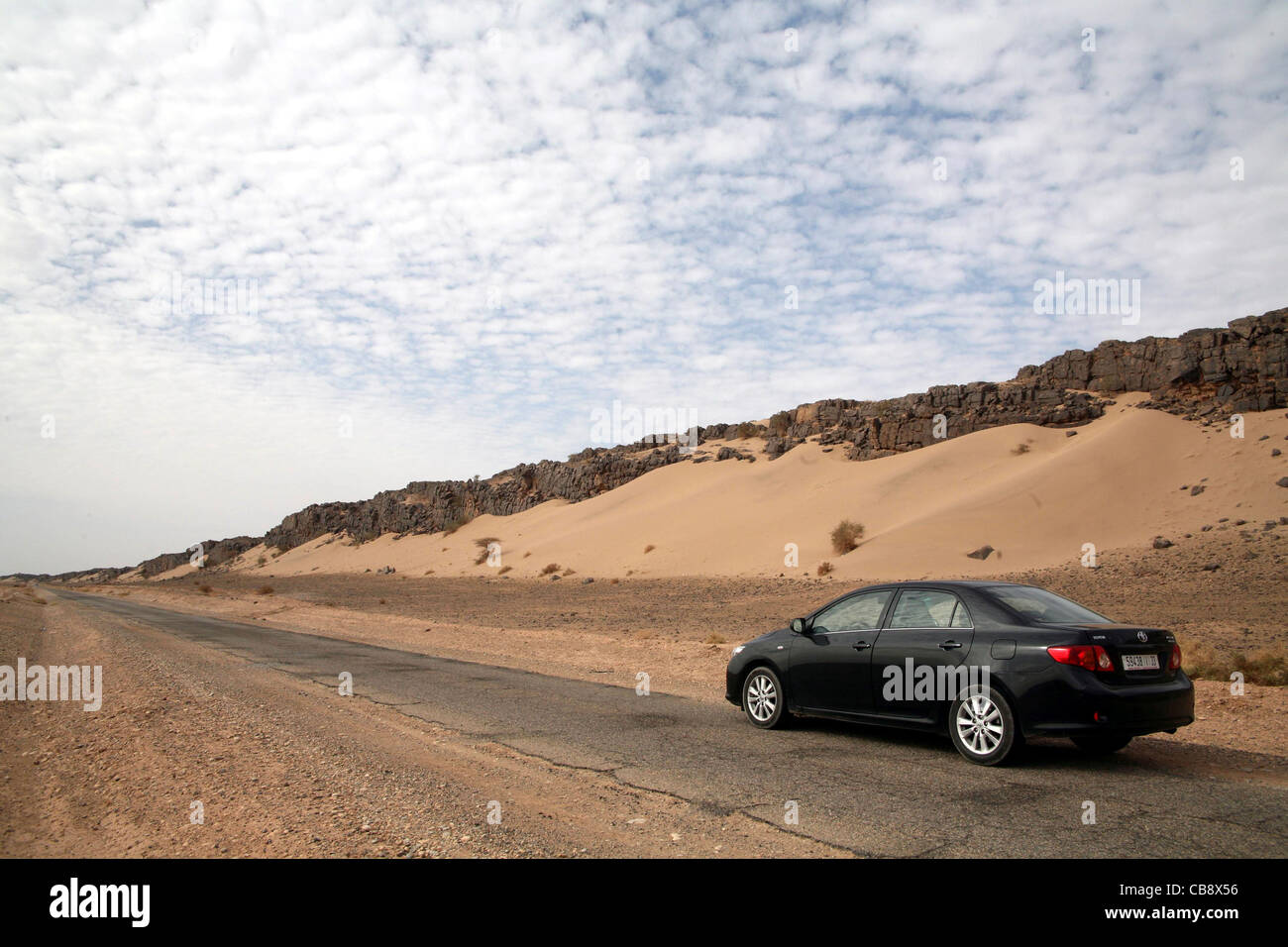 A rent-a-car on the road between Tata and Guelimim in Western Sahara region of Morocco Stock Photo