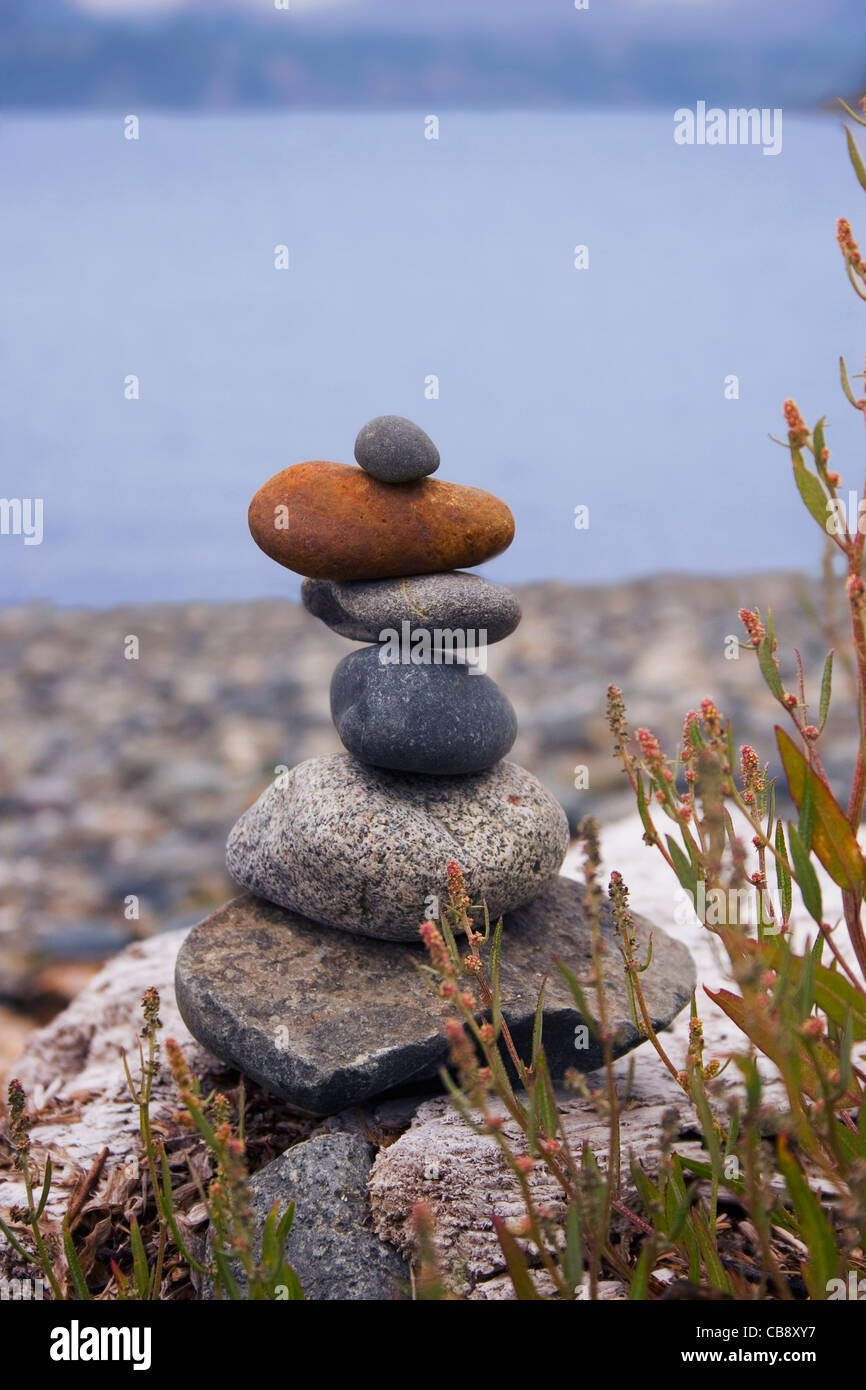 Cairn perched on a rocky beach.  Caption space at the top. Stock Photo