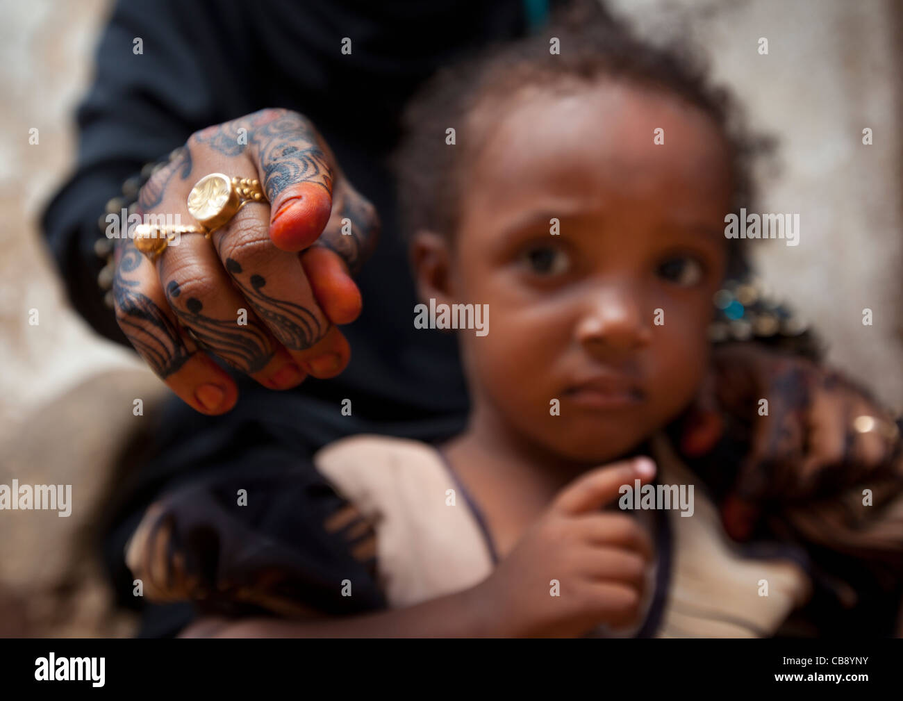 Woman Showing Camera With Henna Painted Hand, Child Worried, Lamu, Kenya Stock Photo