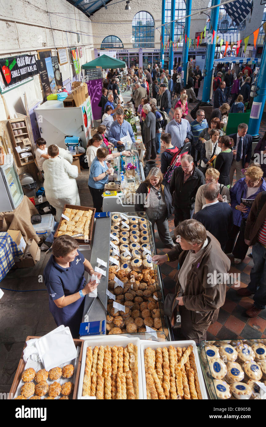 People buying food from stalls in the market hall Abergavenny Food