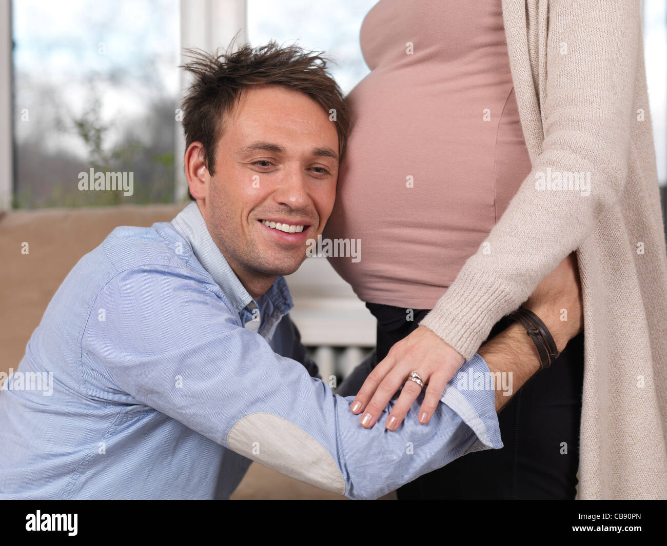 License available at Happy husband listening to baby