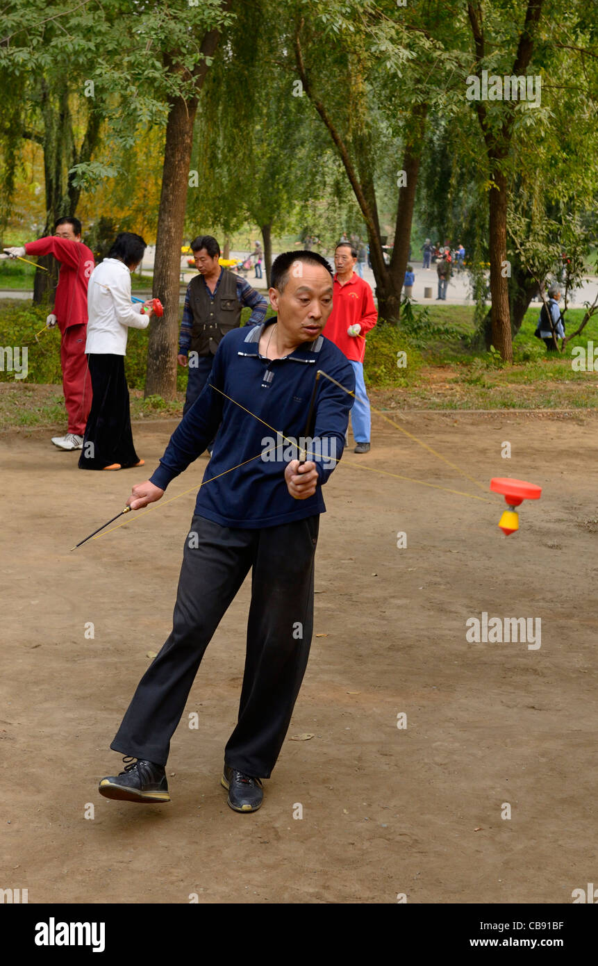 Man spinning a Chinese Yo Yo in Zizhuyuan Purple Bamboo Park in Beijing
