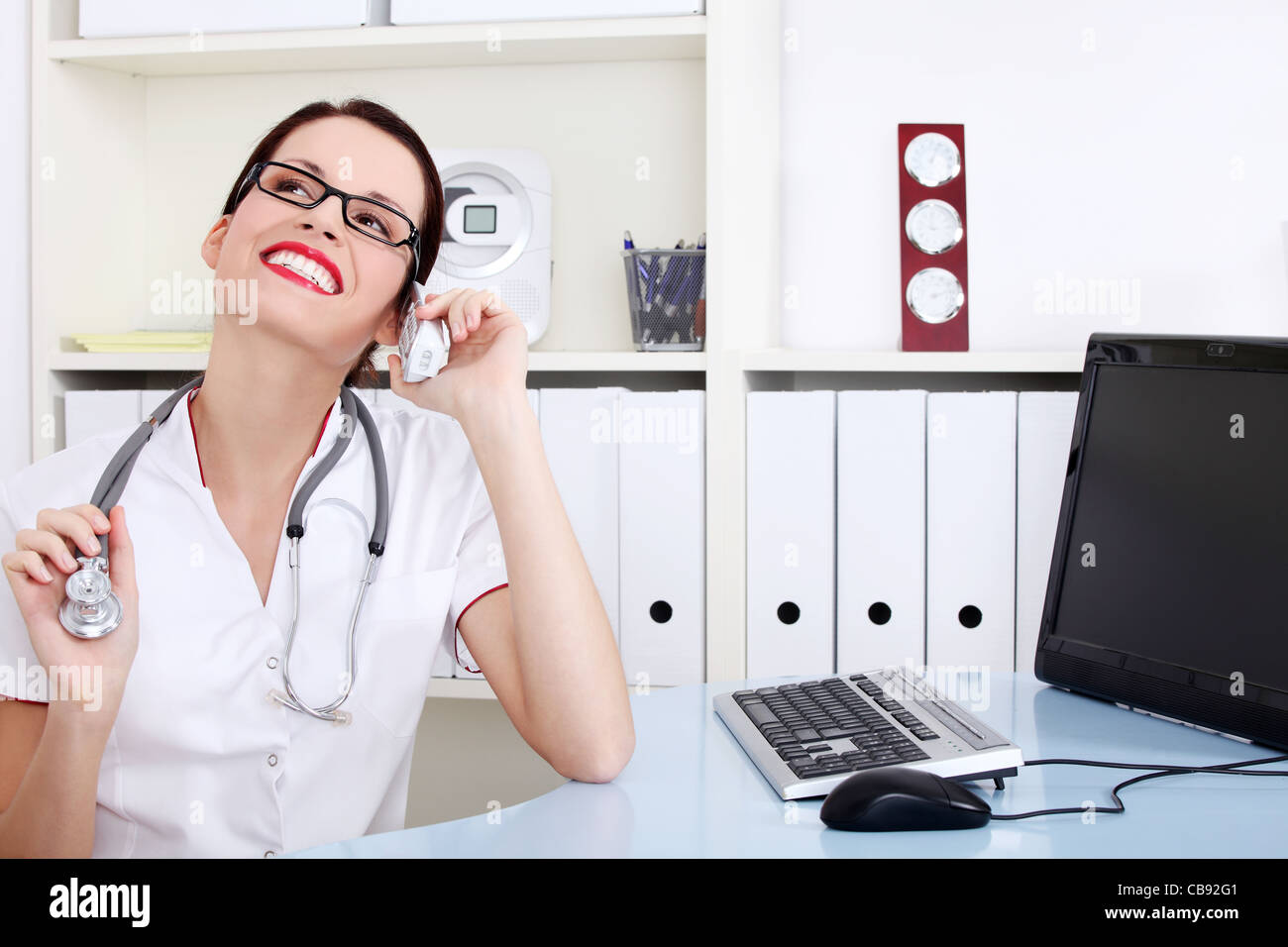 Pretty caucasian female doctor talking by the phone Stock Photo - Alamy