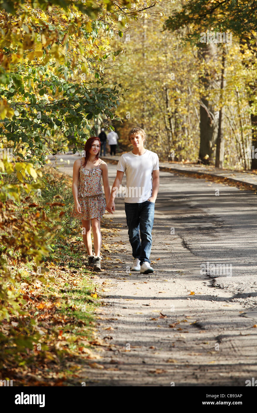 Young caucasian couple walking hand by hand in the park Stock Photo - Alamy