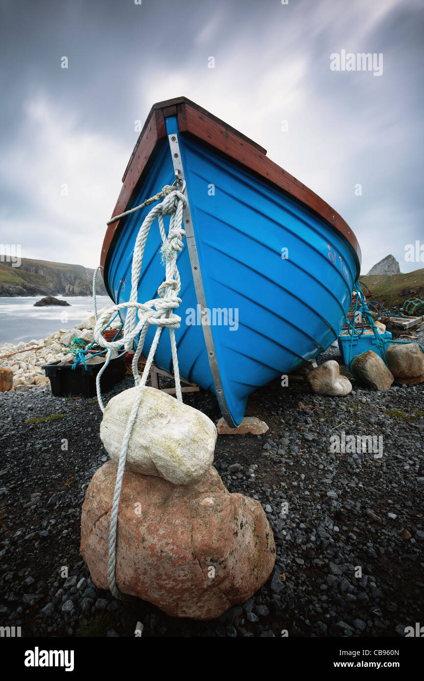 Blue boat weighed down by rocks, County Donegal Ireland Stock Photo