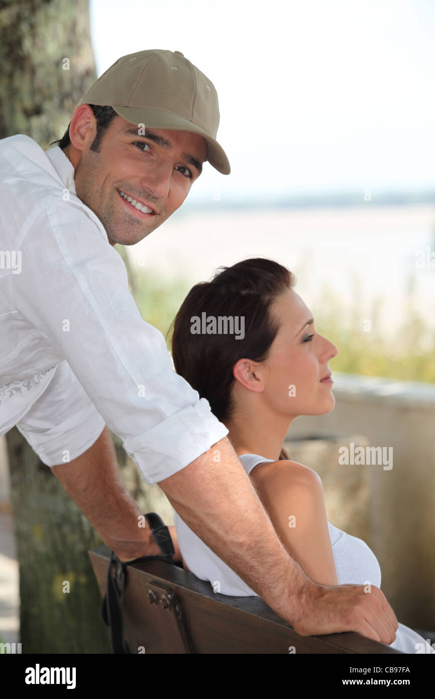 Couple sat on a bench at the seaside Stock Photo - Alamy
