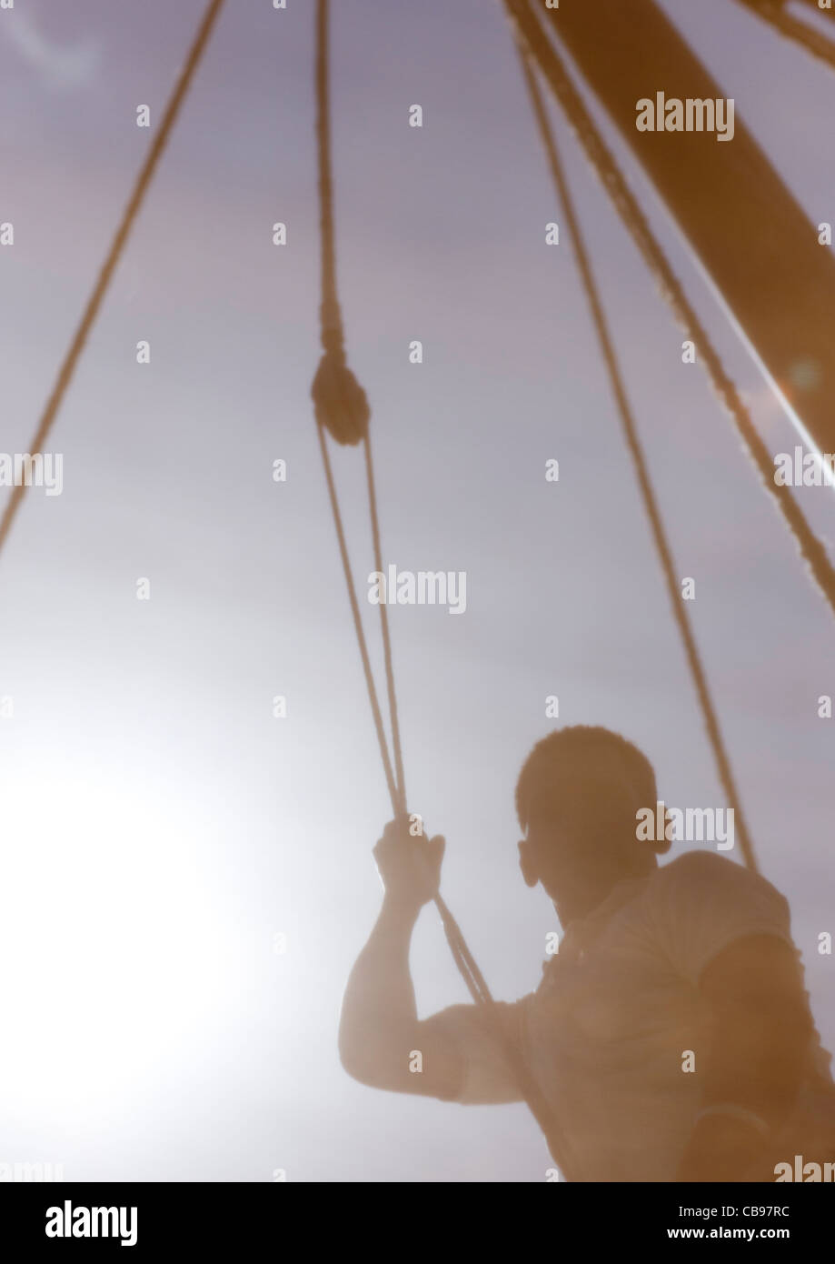 Lamu Kenya Africa swahili man hoisting sail during dhow race maulidi