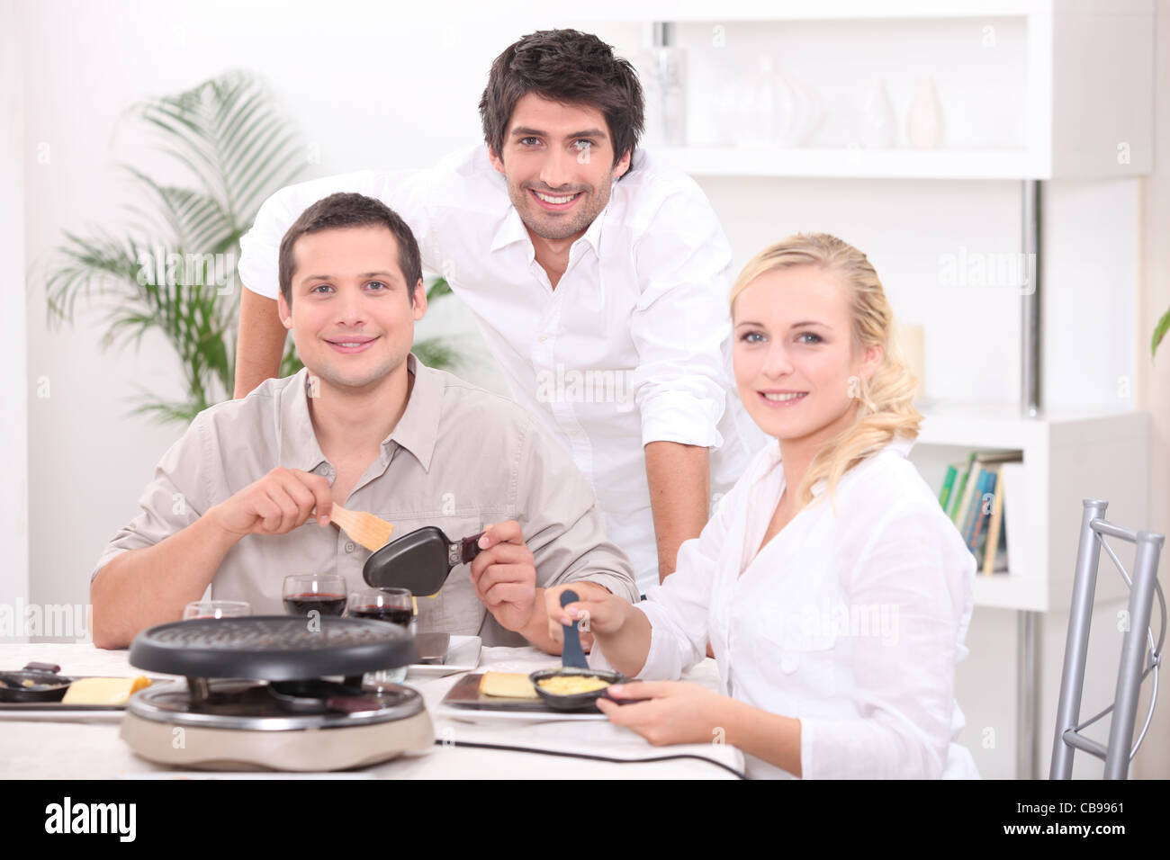Friends eating raclette Stock Photo - Alamy