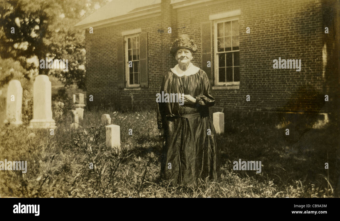 Circa 1900 elderly woman in mourning dress in a cemetery. Stock Photo