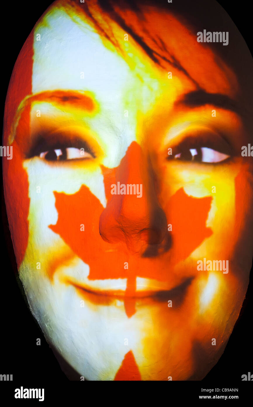 Huge sculpture of a face illuminated by an image of a Canadian flag painted face during the festival of lights 2011 in Berlin Stock Photo