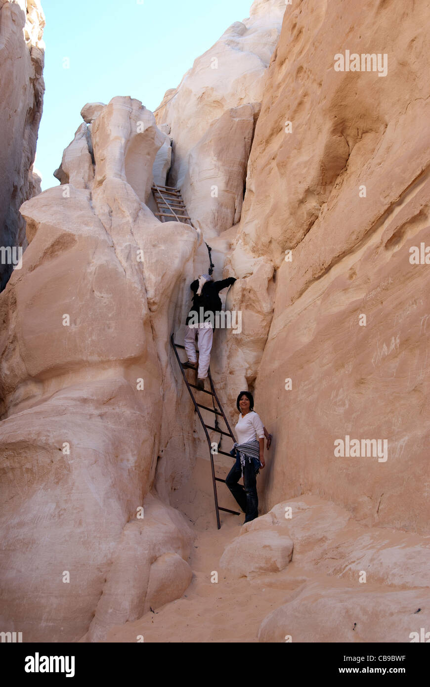 Bedouin guide with tourist climbing stairs in the white canyon - Sinai Peninsula, Egypt Stock Photo