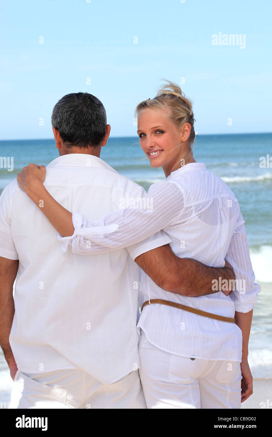 Couple walking along the beach Stock Photo - Alamy