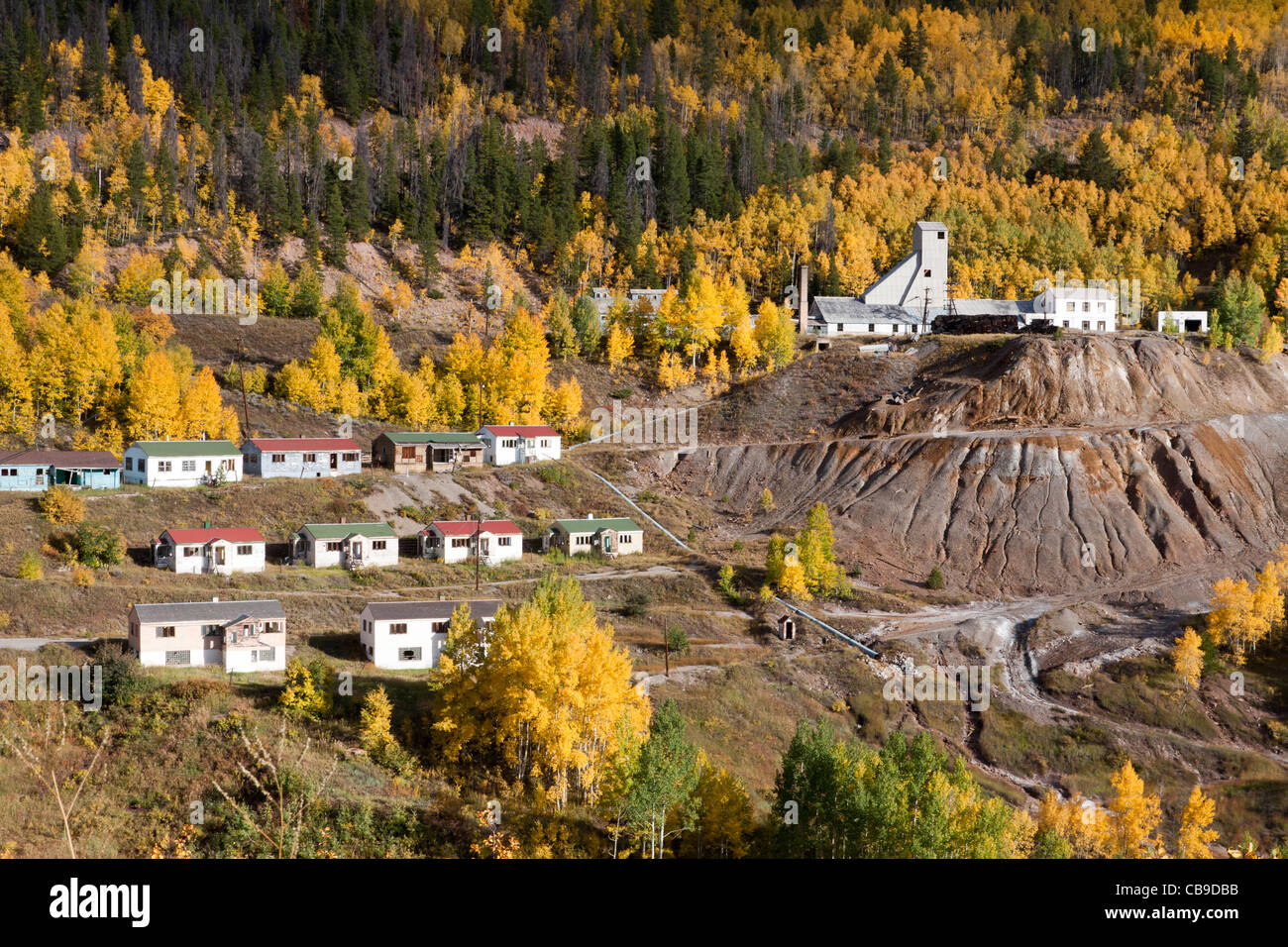 Small mining town in Rocky Mountains of Colorado with simple houses on hillside with aspen trees in autumn Stock Photo