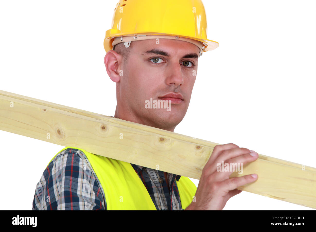 Labourer carrying a wooden plank Stock Photo