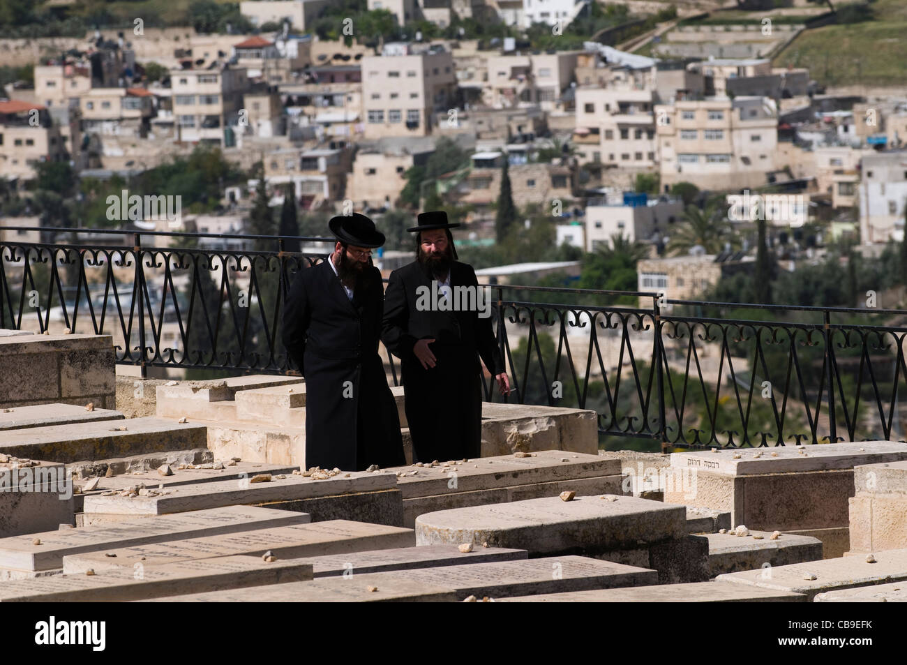 Orthodox Jewish men walking in the Jewish cemetery on the Mount of Olives. Stock Photo