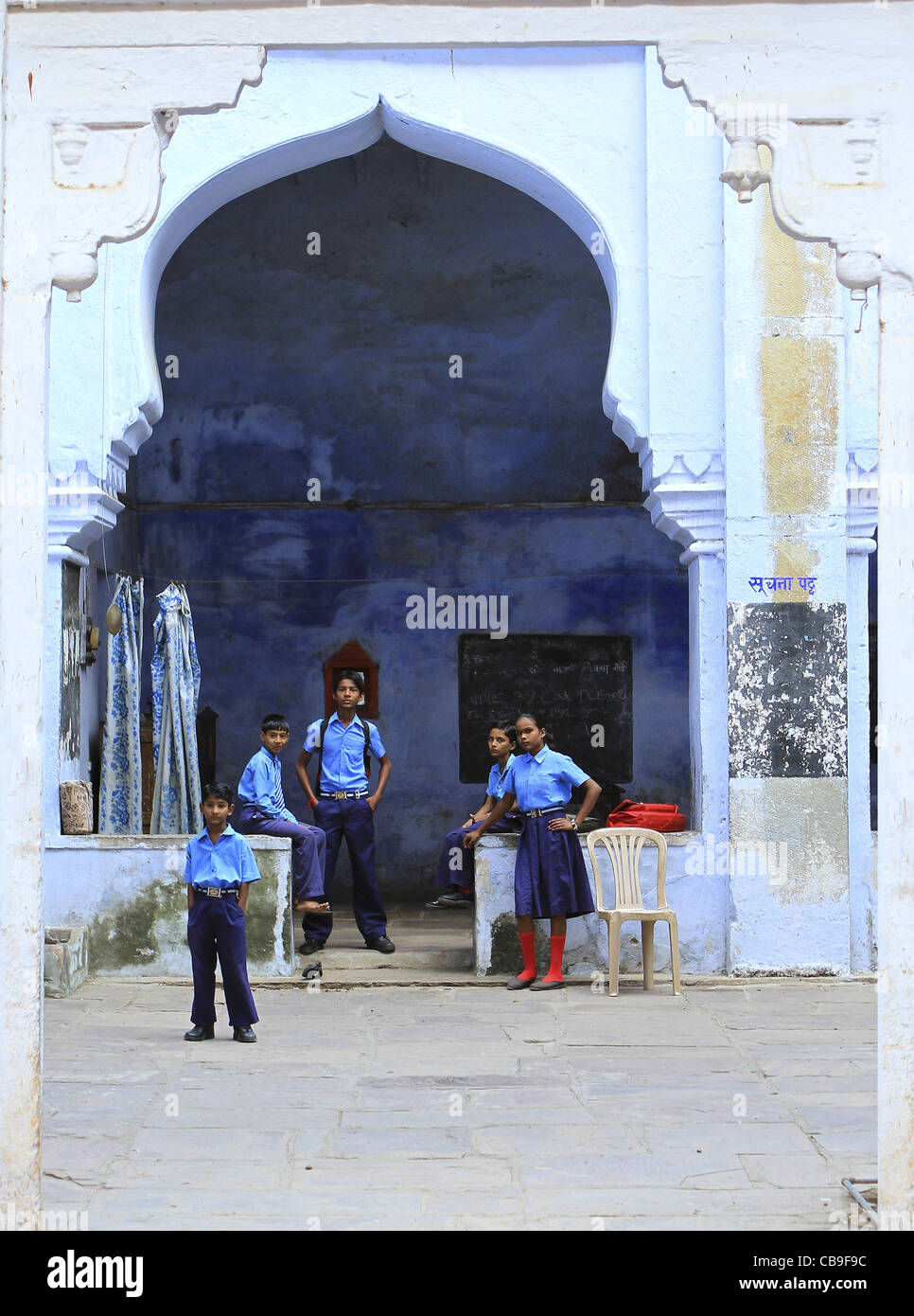 Indian school children standing under a blue arch in Bundi , Rajasthan . India Stock Photo
