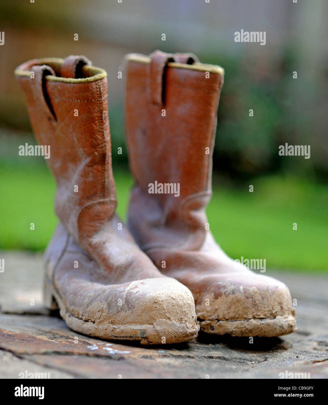 Protective steel toe cap boots covered in mud for building site health and  safety regulations UK Stock Photo - Alamy