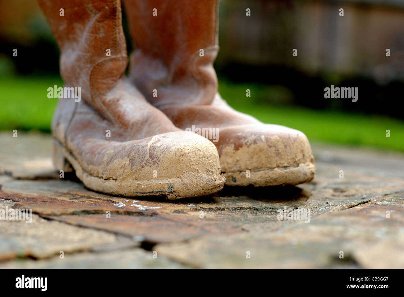 Protective steel toe cap boots covered in mud for building site health