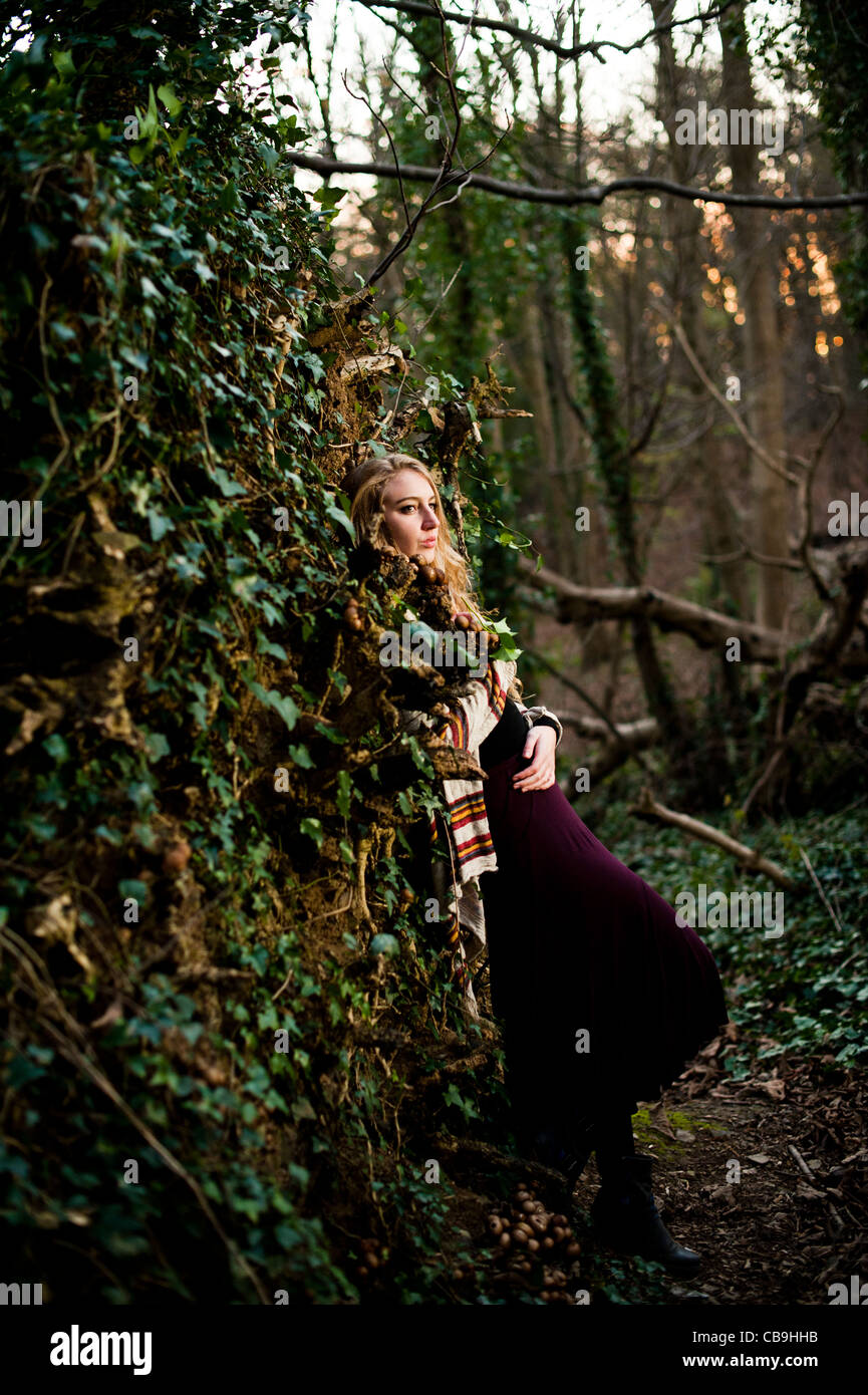 a slim blonde woman girl alone in woodland autumn afternoon daytime UK Stock Photo