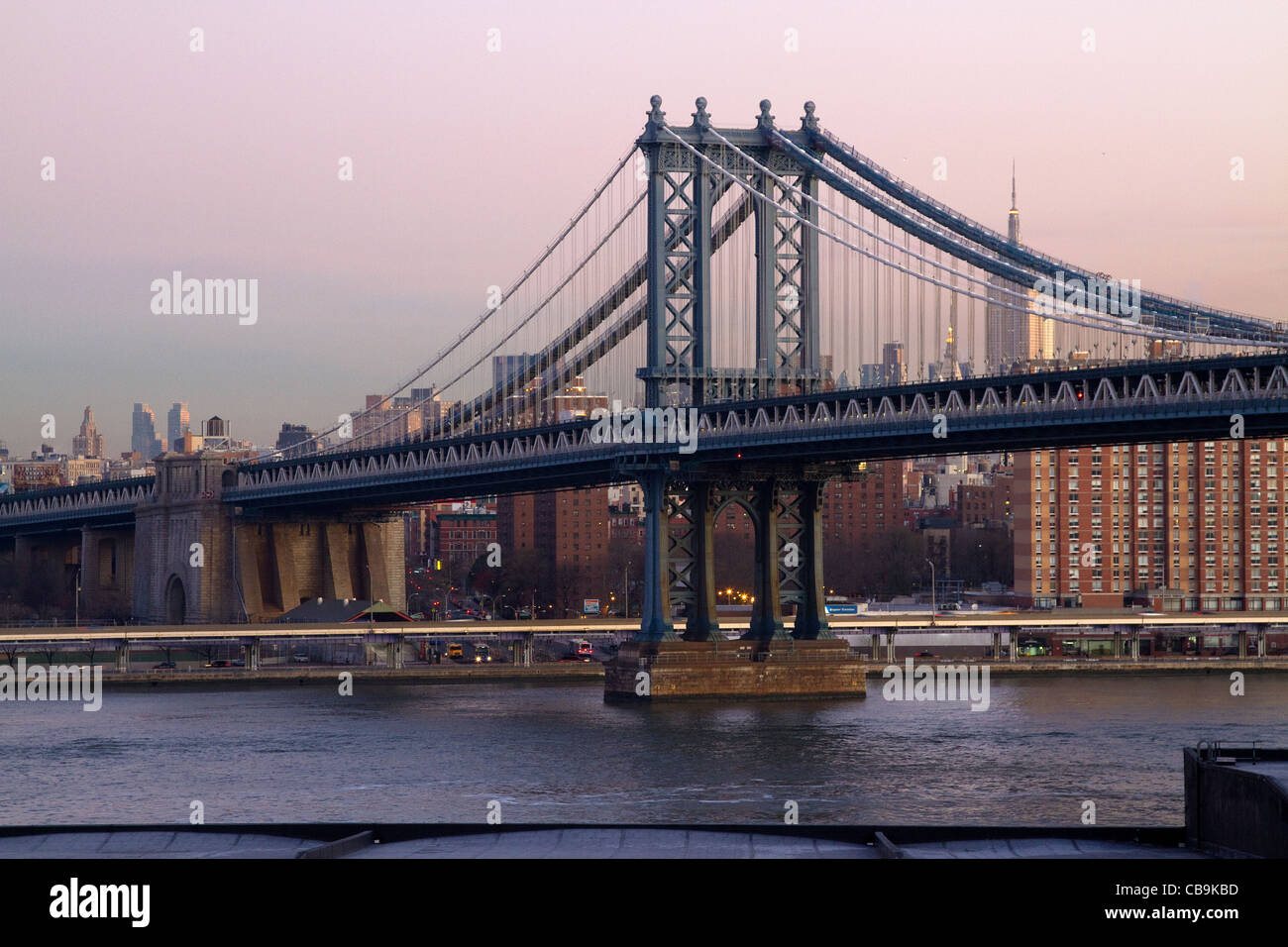 New York City, Manhattan Bridge skyline during the beautiful colors of early morning sunrise, dawn from Brooklyn Bridge. Stock Photo