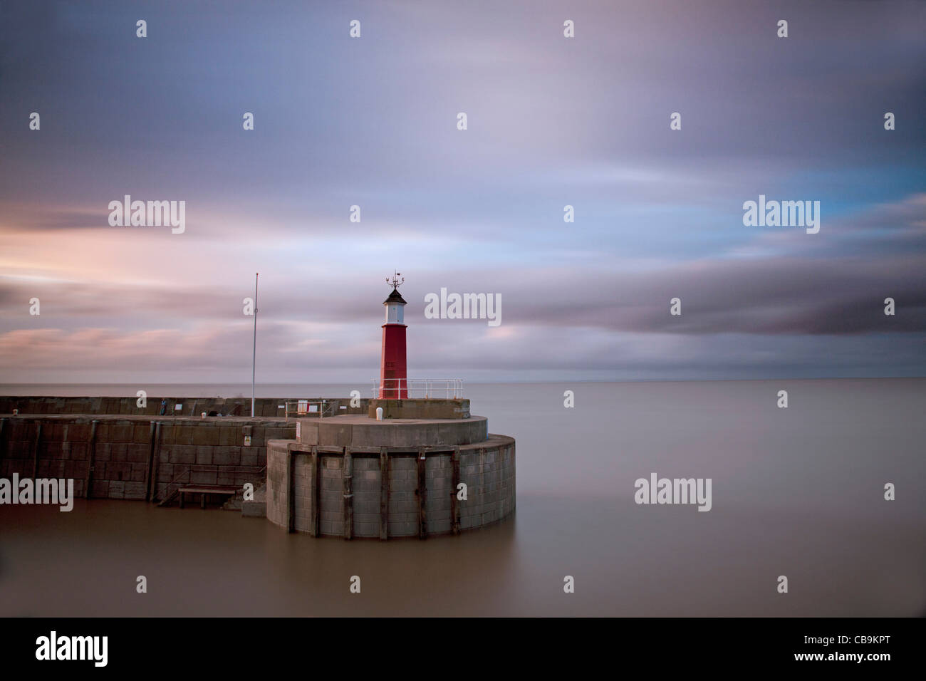 Watchet harbour and lighthouse with softly blurred evening sky. Stock Photo