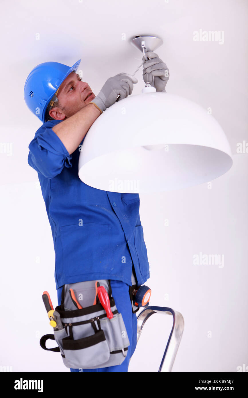 Electrician fitting a ceiling light Stock Photo - Alamy