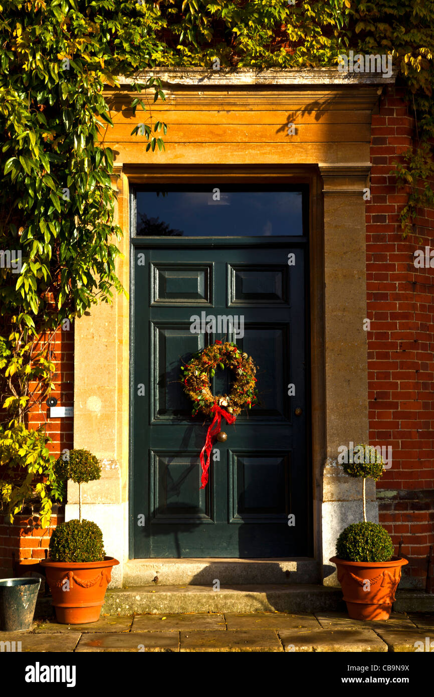 Front Door Of Stately Home Decked with Christmas Wreath Stock Photo