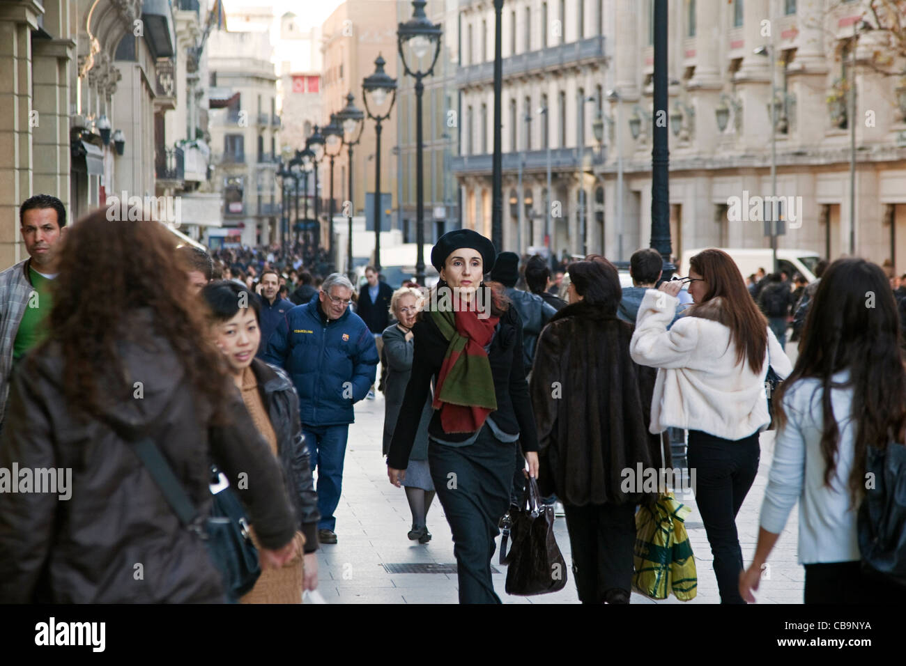 Fashionably dressed woman walking in shopping street in Barcelona, Spain Stock Photo