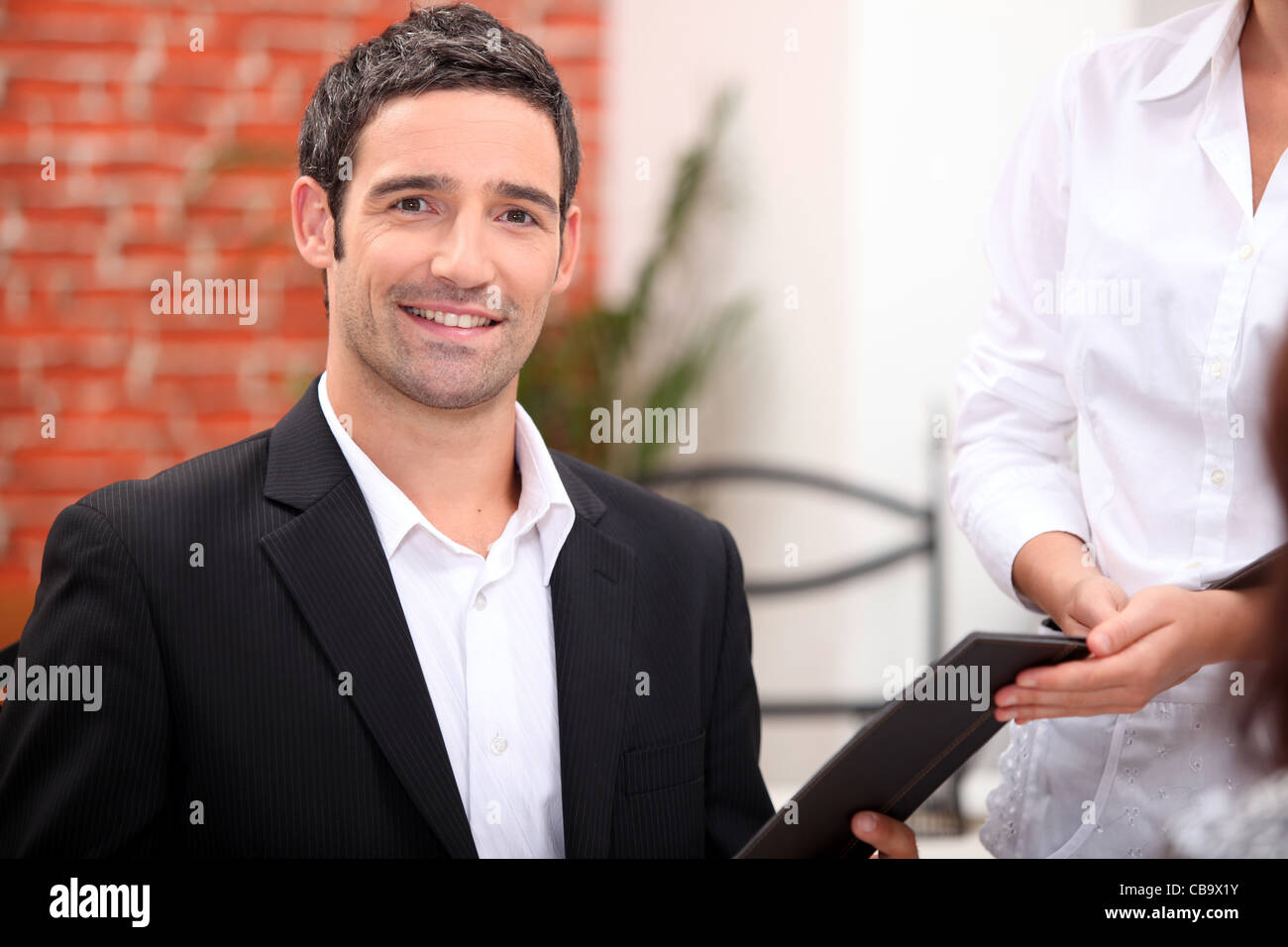 Man being handed menu Stock Photo - Alamy