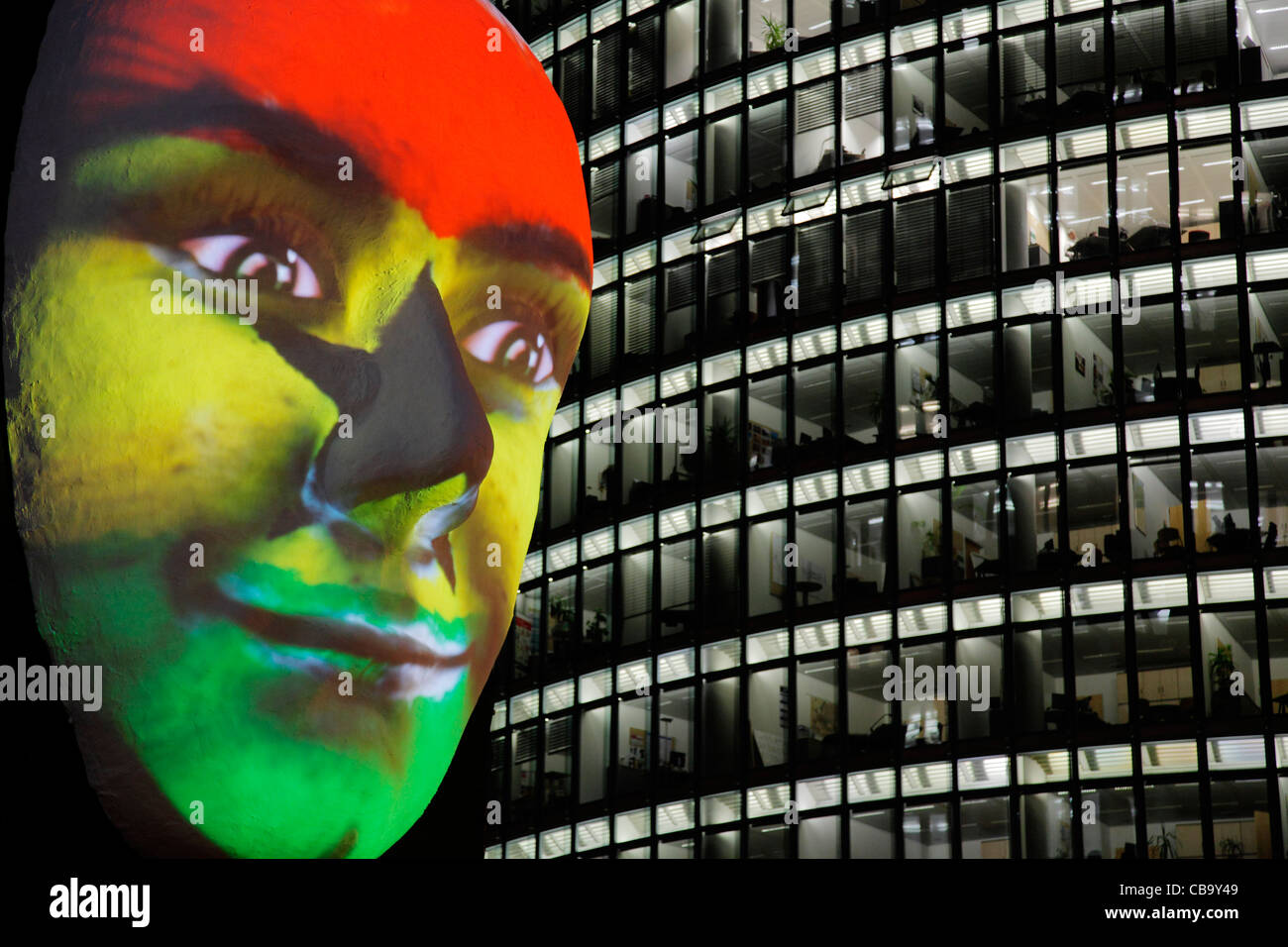 Huge sculpture of a face illuminated by an image of a Ghanaian flag painted face during the festival of lights 2011 in Berlin Stock Photo