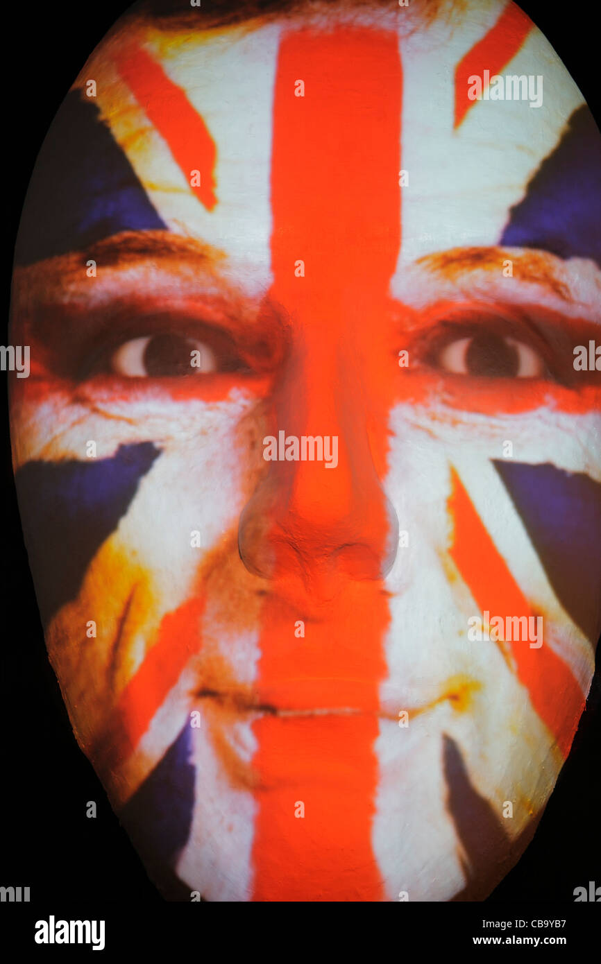 Huge sculpture of a face illuminated by an image of an Union Jack flag painted man during the festival of lights 2011 in Berlin Stock Photo