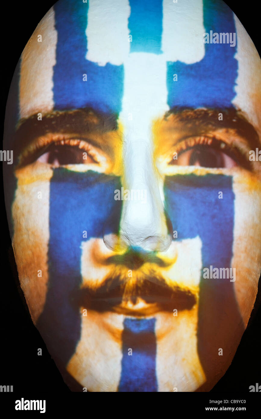 Huge sculpture of a face illuminated by an image of a Grecian flag painted man during the festival of lights 2011 in Berlin Stock Photo