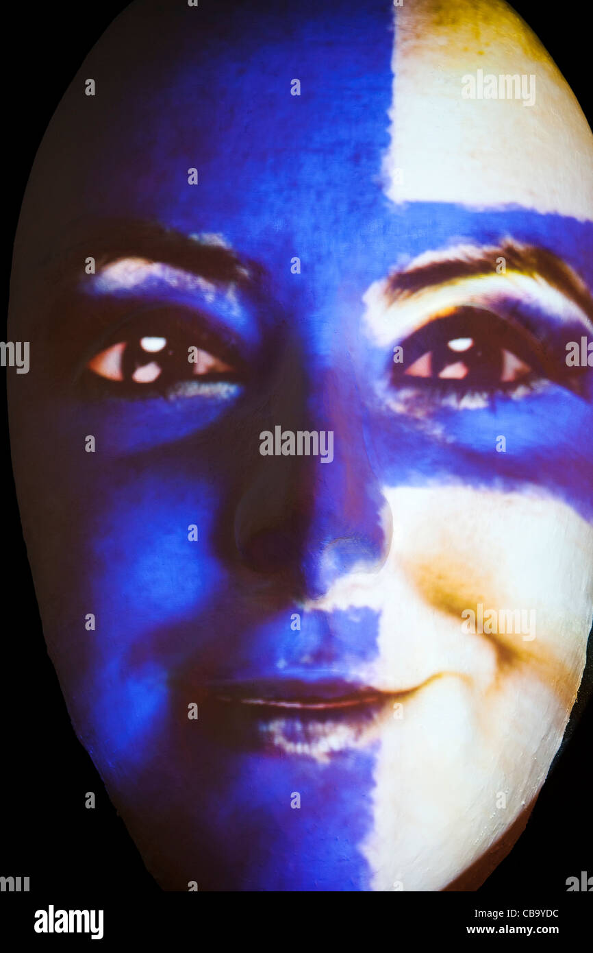 Huge sculpture of a face illuminated by an image of a Finnish flag painted woman during the festival of lights 2011 in Berlin Stock Photo