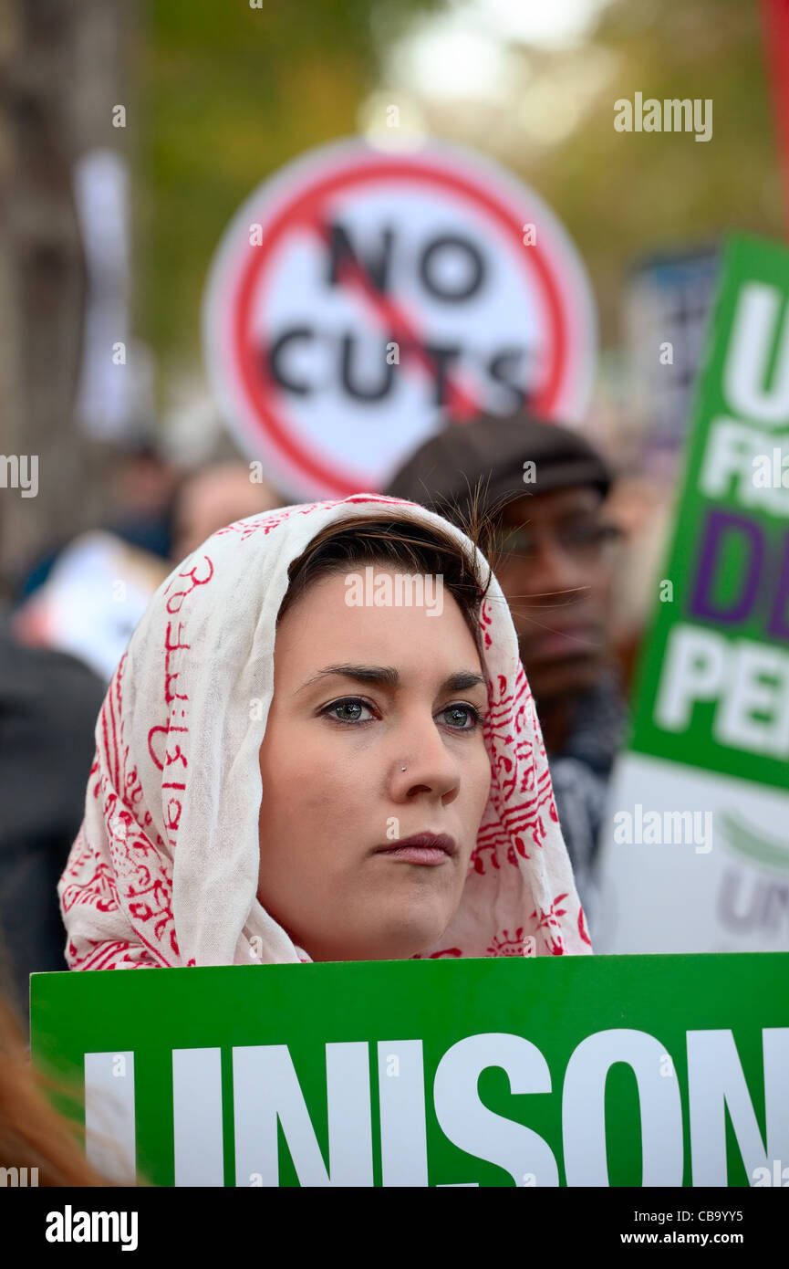 Female protester, with Unison trades union sign, listening to speeches after N30 march, striking over public sector pension cuts Stock Photo