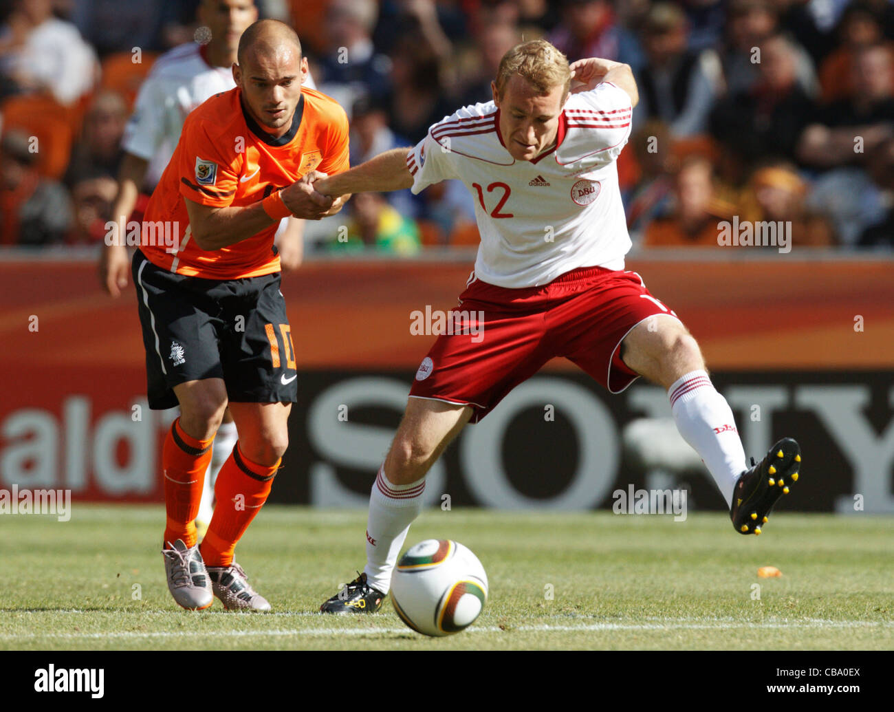 Wesley Sneijder of the Netherlands (L) holds Thomas Kahlenberg of Denmark (R) during a 2010 FIFA World Cup match. Stock Photo