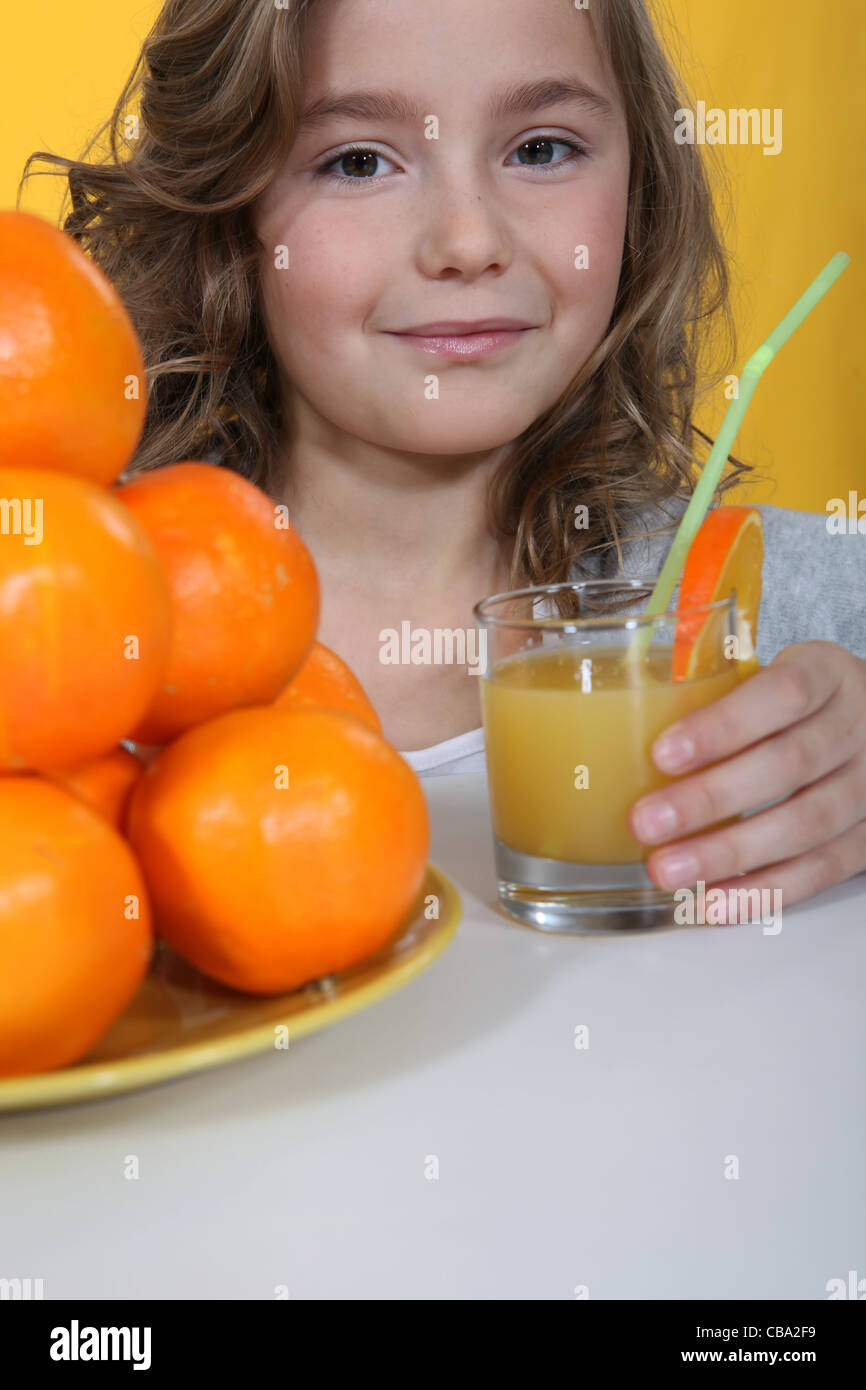 Little girl drinking orange juice Stock Photo - Alamy