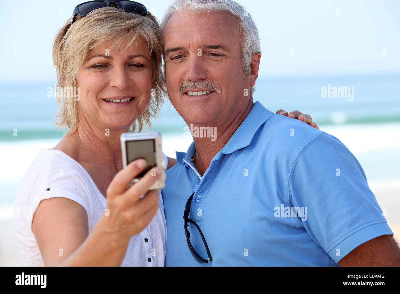 Mature couple taking a picture of themselves by the sea Stock Photo