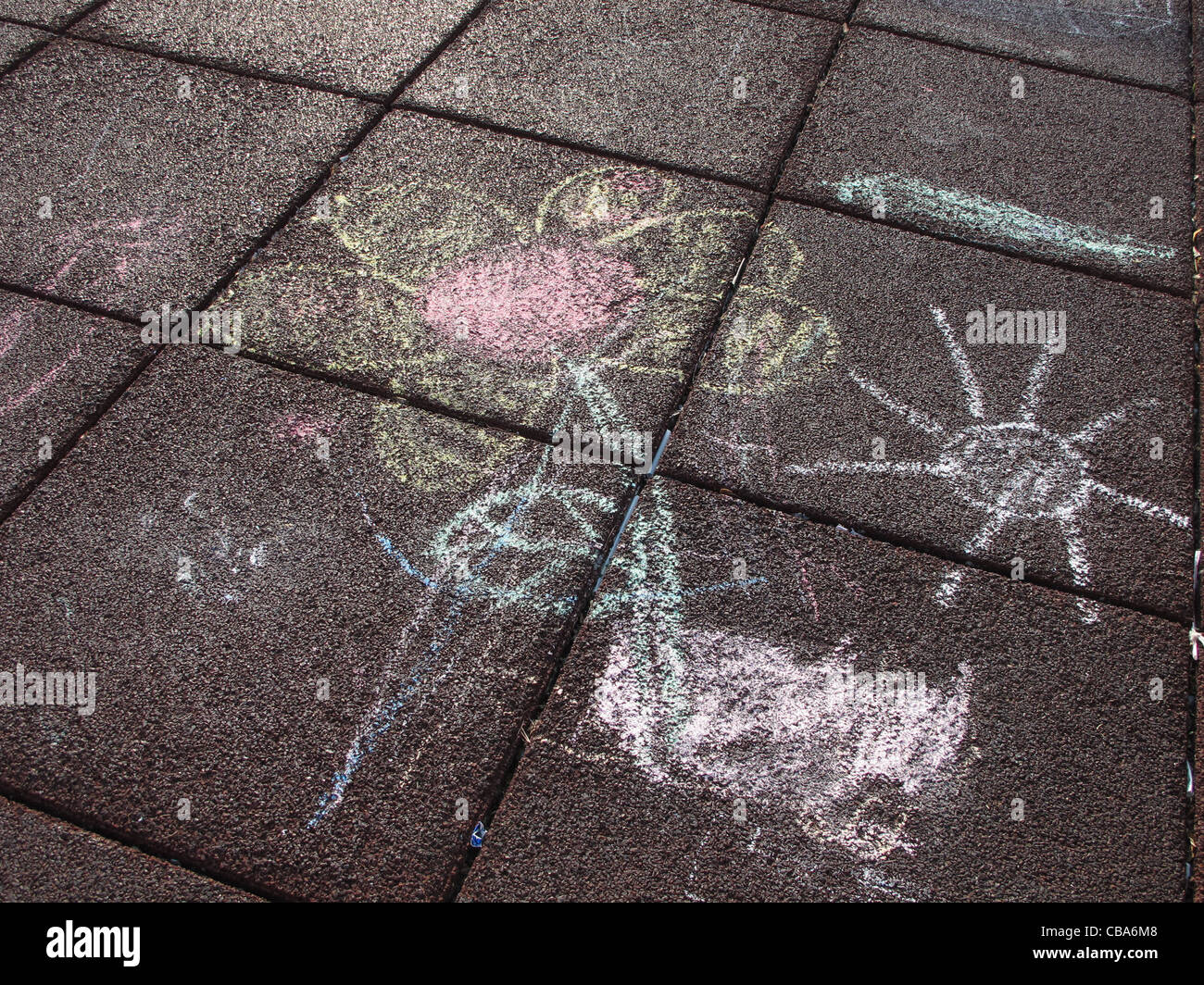 chalk drawing of flower and sun on playground floor Stock Photo