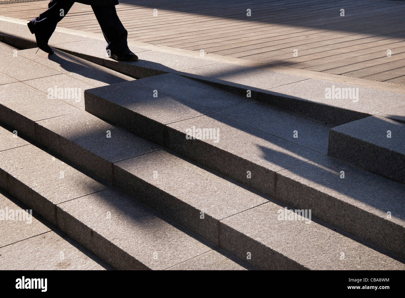 anonymous person walking shadows and footsteps on concrete steps Stock Photo