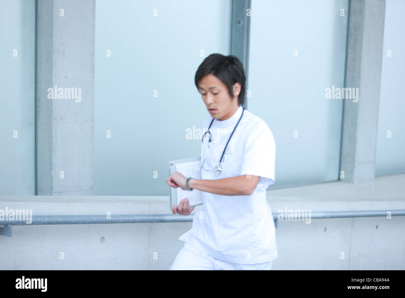 Young Male Doctor Checking The Time Stock Photo - Alamy