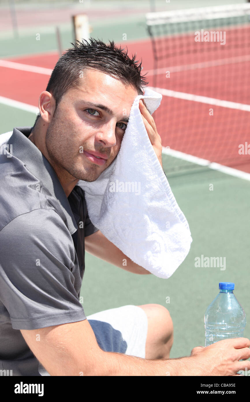 Полотенце на лбу. Сербский теннисист вытирает газон. Протирает лоб футболкой. Вытирать лоб галстуком.