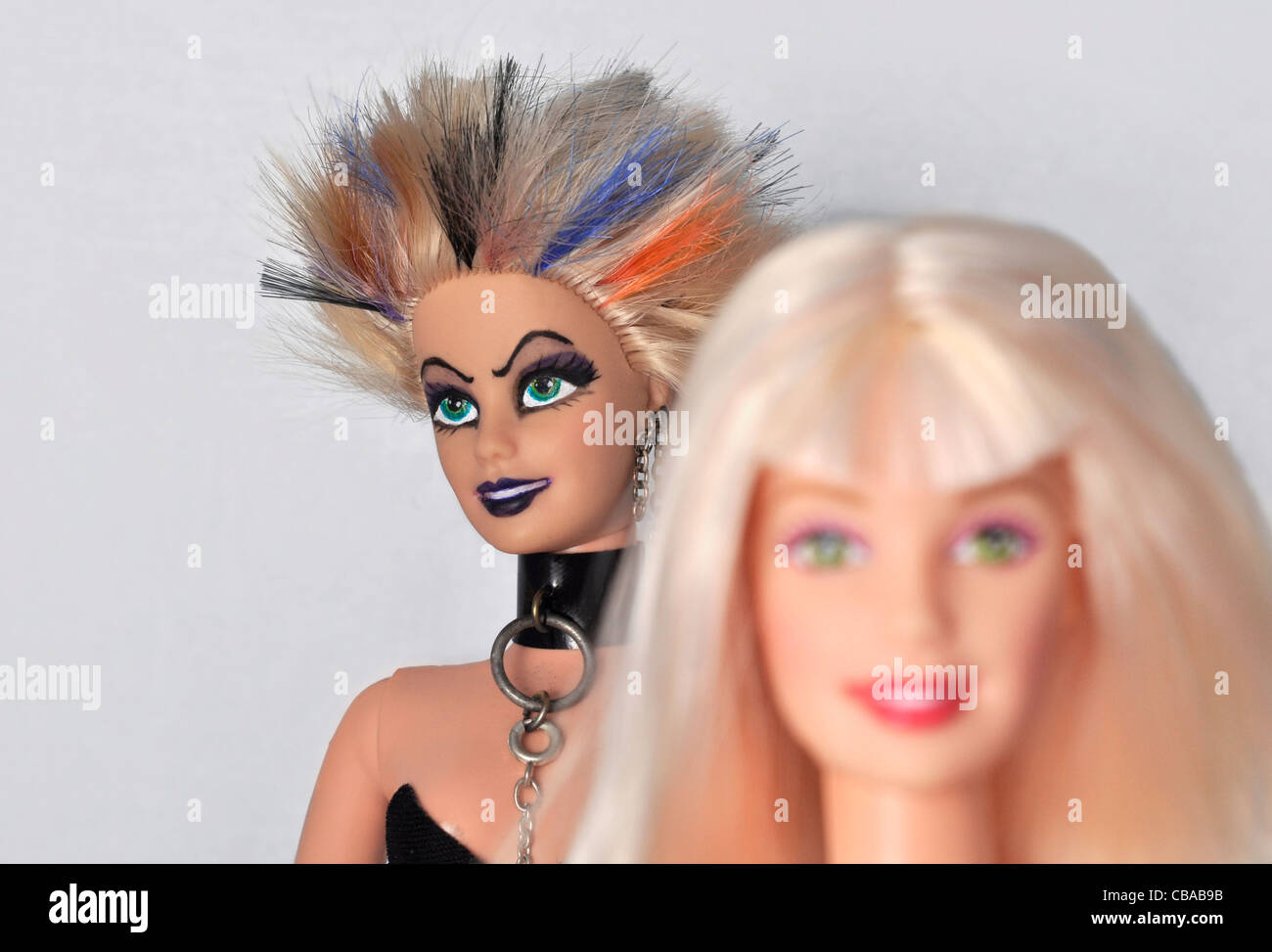 Punk Barbie doll with unruly multicoloured hair stands behind an of focus, "perfect" blonde barbie Stock Photo - Alamy