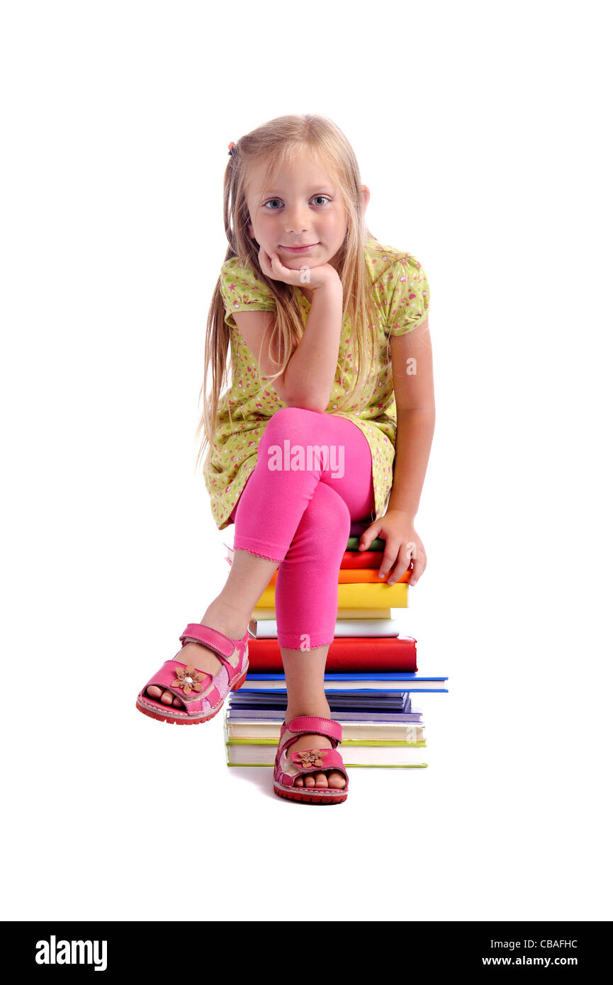 Back to school. Girl sitting on a stack of books Stock Photo - Alamy